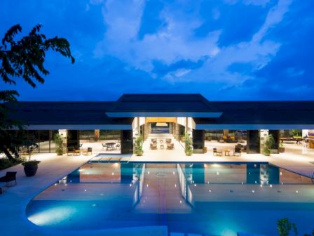 A modern building with a pool, illuminated at night.
