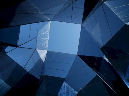 Geometric glass structures reflecting the sky.